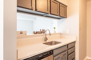 A kitchen with a stainless steel sink and a black dishwasher at BellaVista Apartments in Woodbridge, VA